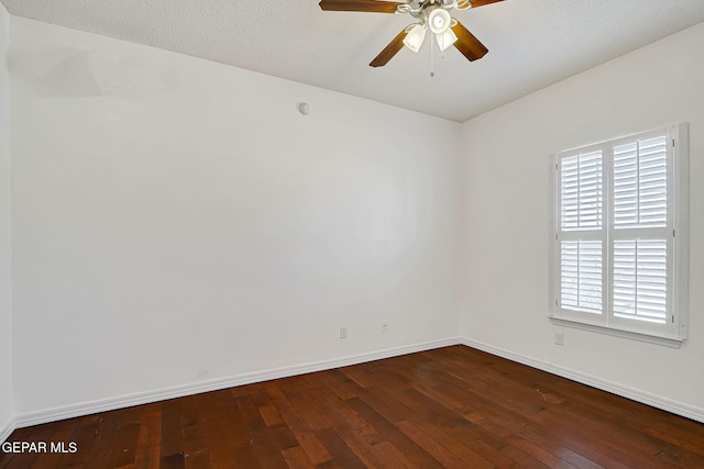 unfurnished room featuring baseboards, ceiling fan, and dark wood-style flooring