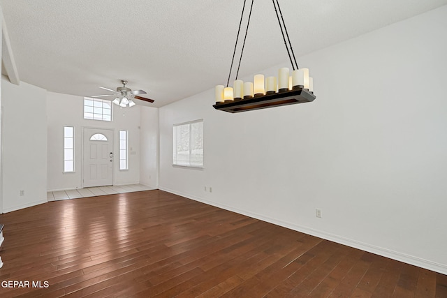 entryway featuring a textured ceiling, hardwood / wood-style flooring, baseboards, and ceiling fan