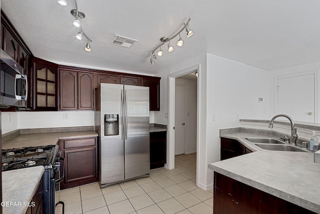 kitchen featuring visible vents, light countertops, stainless steel appliances, a textured ceiling, and a sink