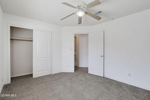 unfurnished bedroom with visible vents, a closet, carpet flooring, baseboards, and ceiling fan