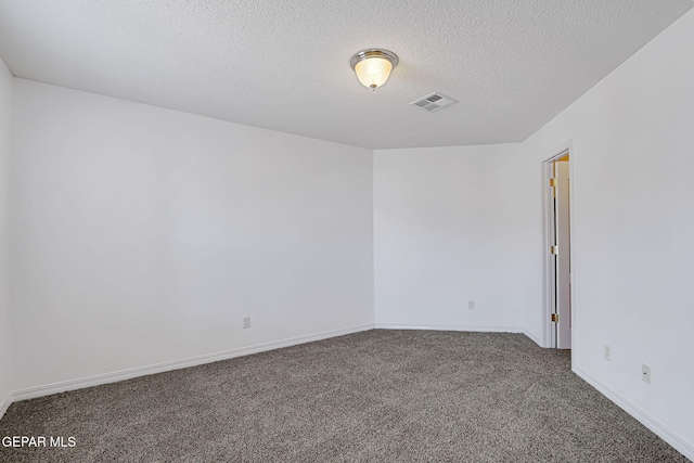 carpeted empty room featuring baseboards, visible vents, and a textured ceiling