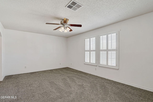 carpeted spare room with baseboards, visible vents, a textured ceiling, and ceiling fan