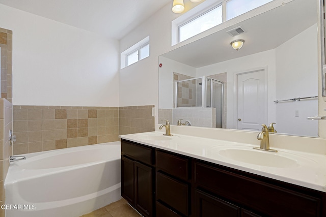 bathroom featuring visible vents, a shower stall, a garden tub, and a sink