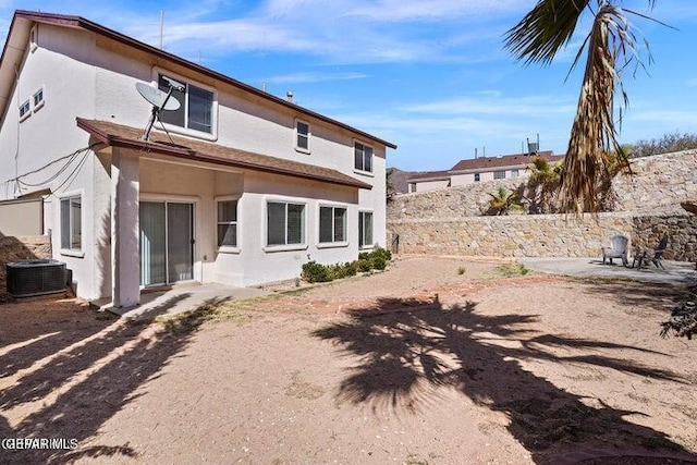 rear view of house featuring stucco siding and cooling unit