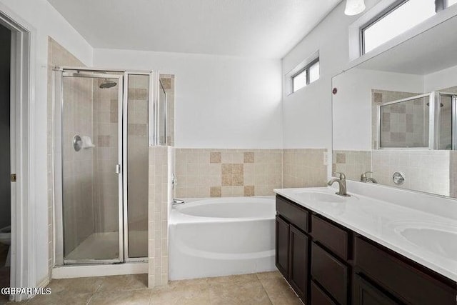 bathroom featuring a bath, a shower stall, tile patterned floors, and a sink