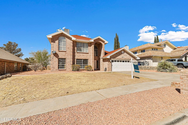 traditional-style home with brick siding, driveway, an attached garage, and a chimney