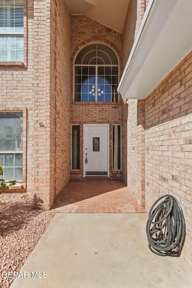 entrance to property featuring brick siding