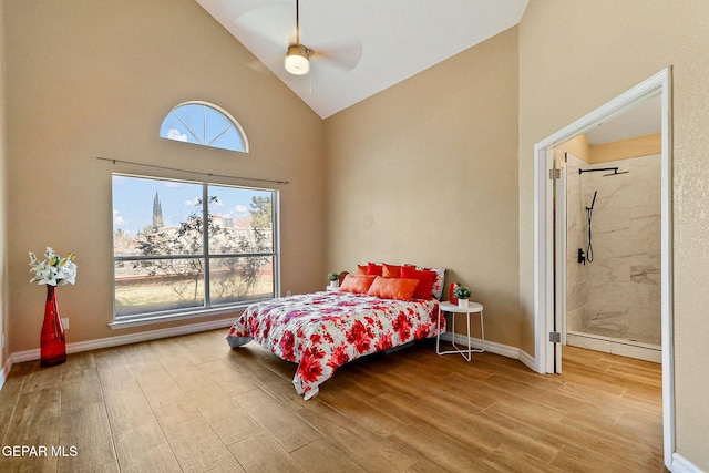 bedroom featuring multiple windows, high vaulted ceiling, baseboards, and wood finished floors