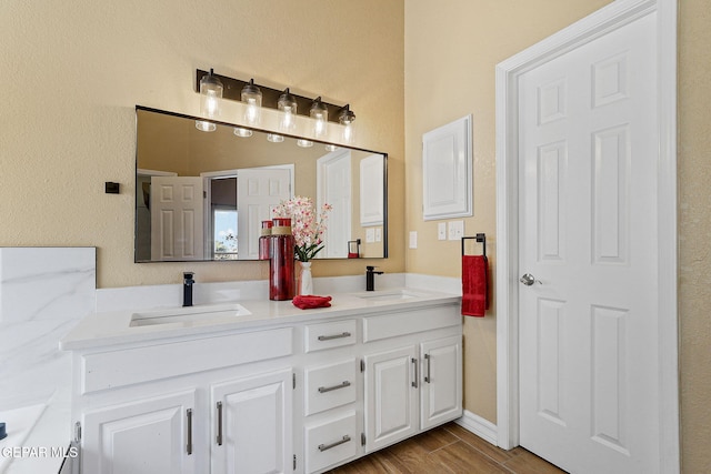 full bathroom featuring double vanity, wood tiled floor, and a sink