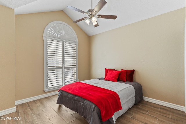 bedroom with baseboards, a ceiling fan, wood tiled floor, and vaulted ceiling