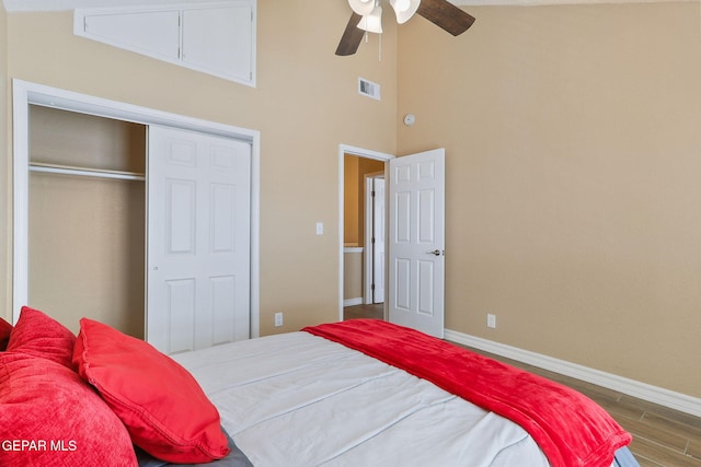 bedroom featuring visible vents, ceiling fan, baseboards, wood finished floors, and a closet