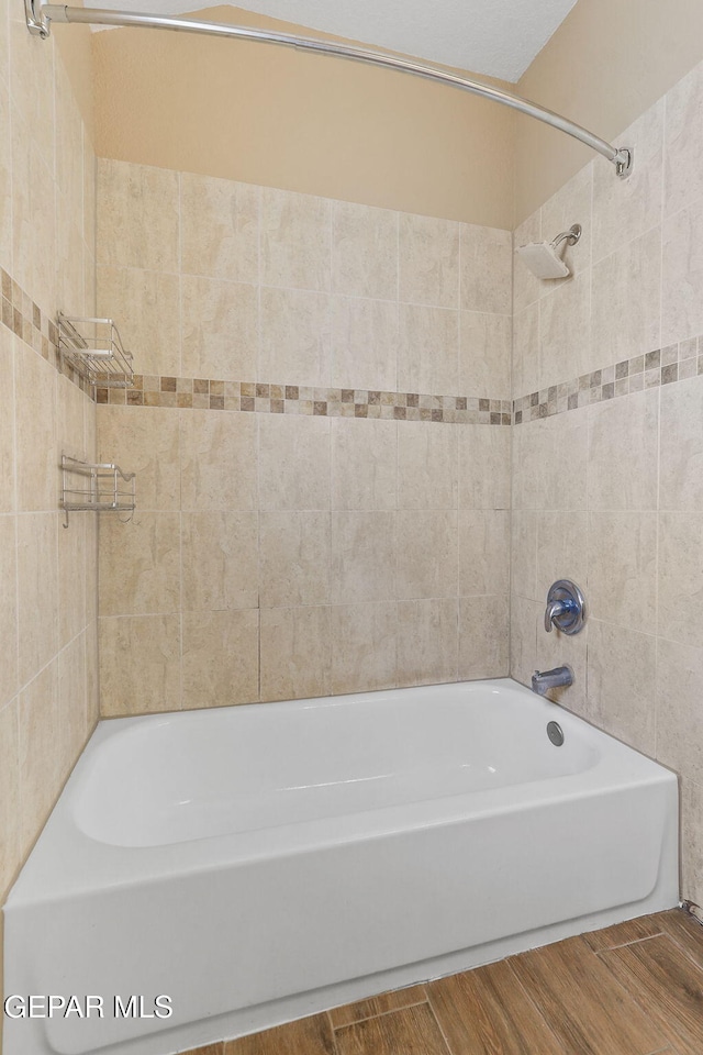 full bath with washtub / shower combination and wood tiled floor