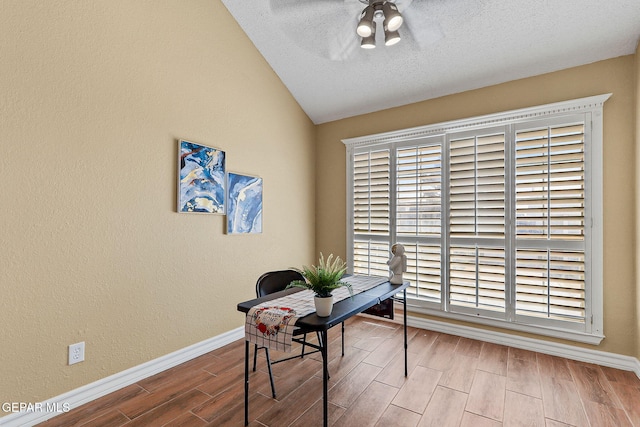 home office featuring vaulted ceiling, baseboards, a ceiling fan, and wood tiled floor