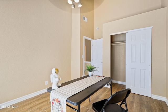 office space featuring a ceiling fan, wood finished floors, visible vents, and baseboards