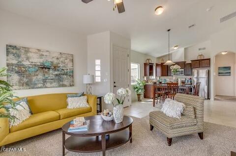 living area with a ceiling fan and vaulted ceiling