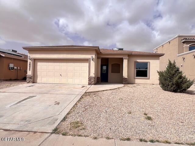 view of front of property with stone siding, stucco siding, an attached garage, and concrete driveway