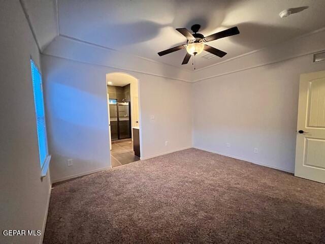 spare room with carpet floors, arched walkways, and ceiling fan