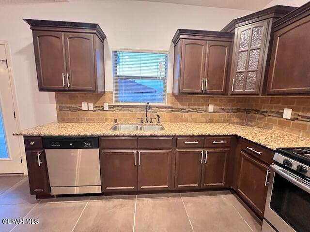 kitchen with a sink, light stone countertops, tasteful backsplash, and stainless steel appliances