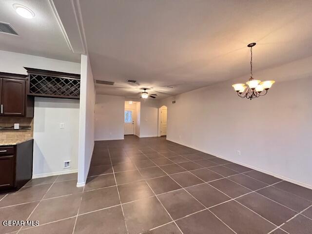 interior space with dark tile patterned flooring, a notable chandelier, and visible vents