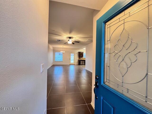 entrance foyer featuring dark tile patterned floors, visible vents, baseboards, and ceiling fan