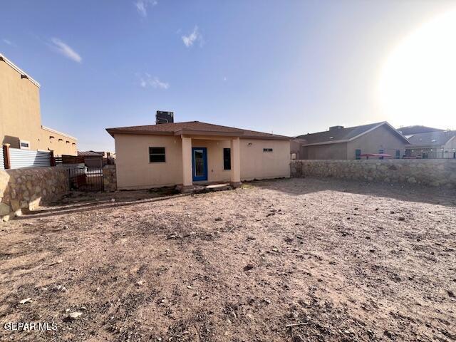 rear view of property with a chimney and fence