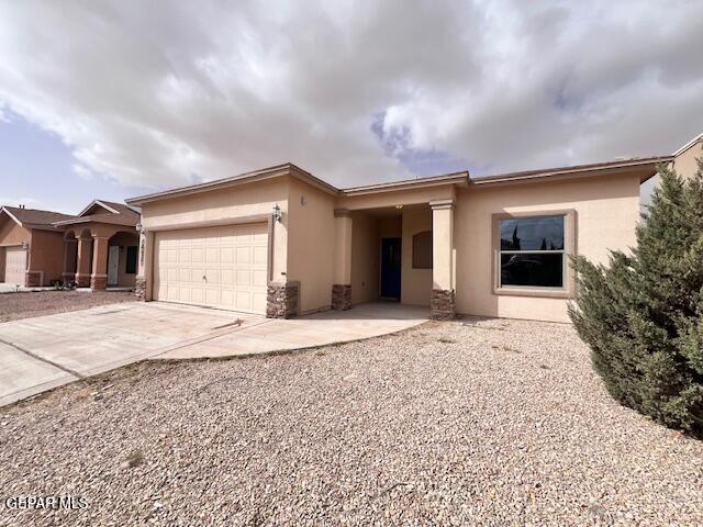 ranch-style home with stucco siding, an attached garage, and driveway