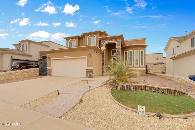 mediterranean / spanish-style home with stone siding, stucco siding, an attached garage, and concrete driveway