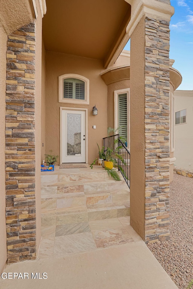 entrance to property featuring stucco siding