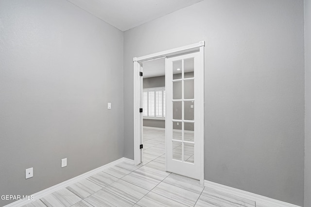 unfurnished room with baseboards