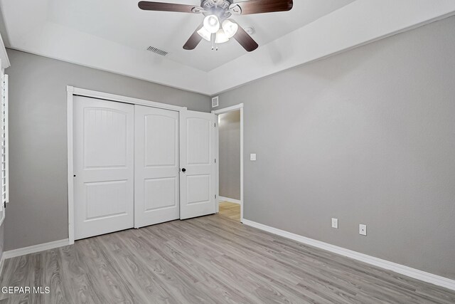 unfurnished bedroom with visible vents, baseboards, light wood-style floors, and a closet