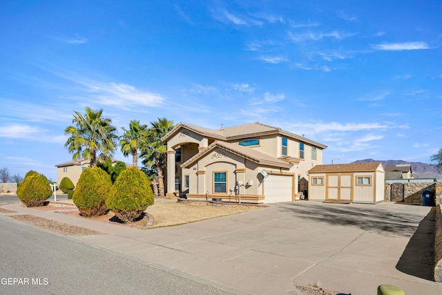 mediterranean / spanish home featuring a tiled roof, a garage, driveway, and stucco siding