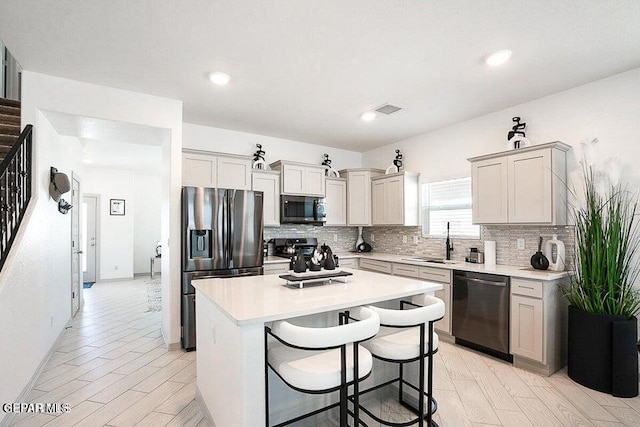 kitchen featuring backsplash, stainless steel appliances, light countertops, and a sink