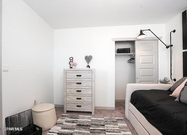carpeted bedroom with baseboards and a closet
