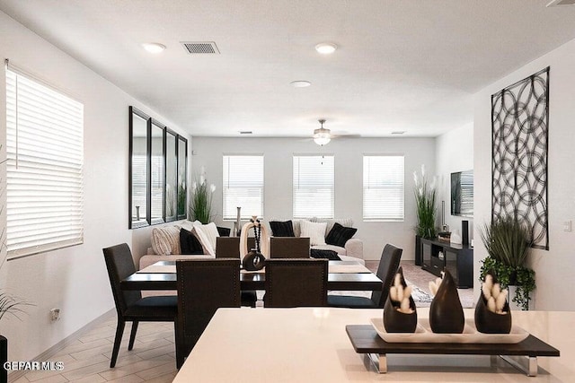 dining space featuring wood finished floors, visible vents, and ceiling fan