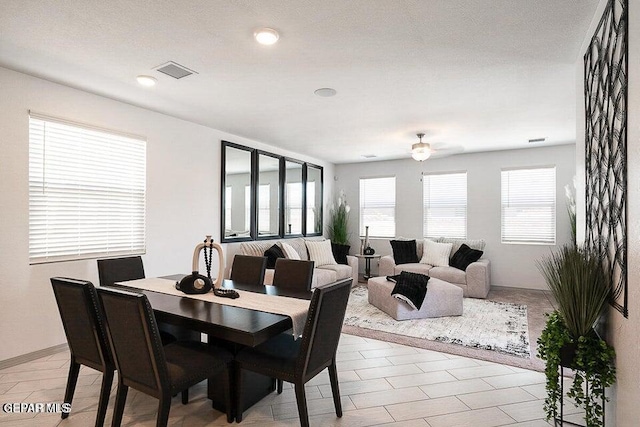 dining room featuring a ceiling fan, visible vents, and a wealth of natural light