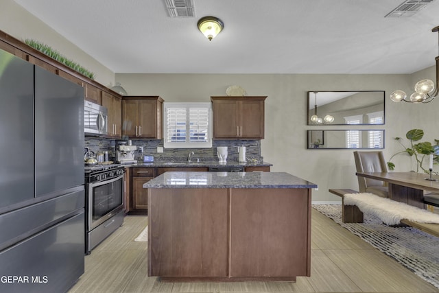 kitchen with a center island, visible vents, backsplash, and stainless steel appliances