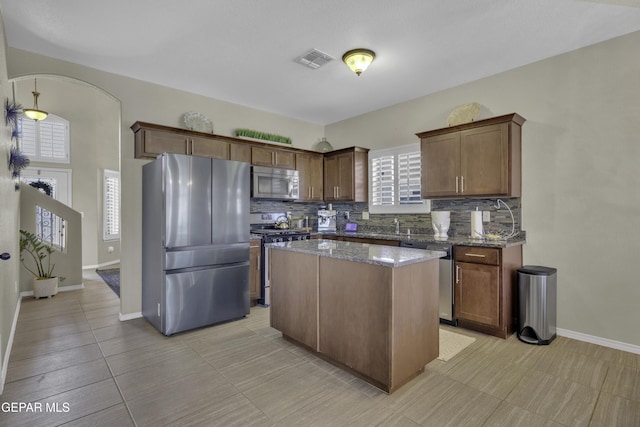 kitchen featuring tasteful backsplash, visible vents, appliances with stainless steel finishes, and dark stone counters