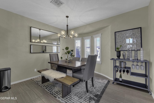 tiled dining space with baseboards, visible vents, and a chandelier