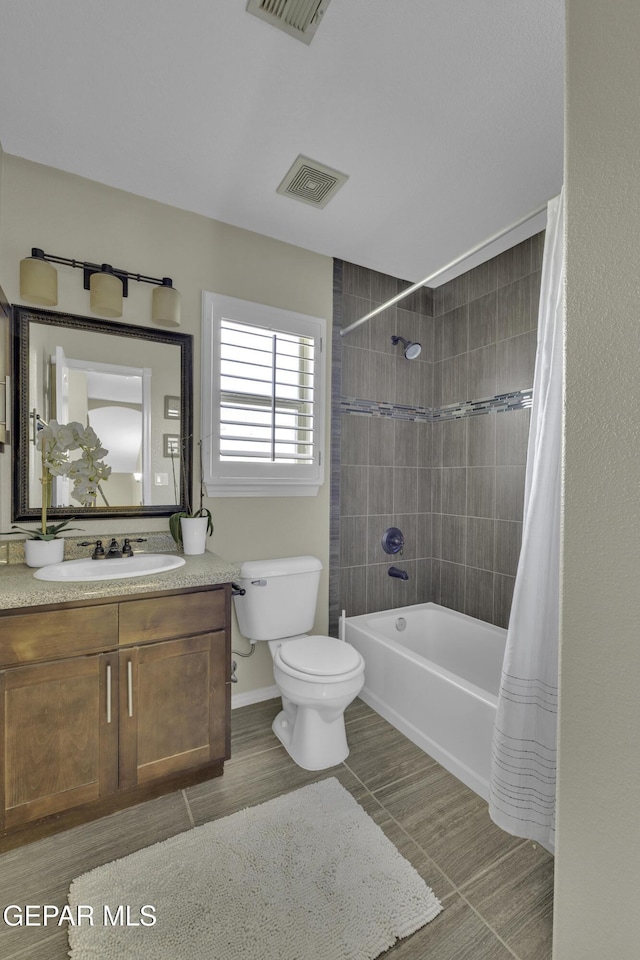 bathroom featuring shower / bath combination with curtain, visible vents, toilet, and vanity