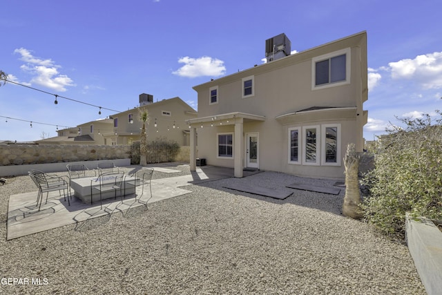 rear view of property featuring stucco siding, central AC, fence, outdoor lounge area, and a patio area