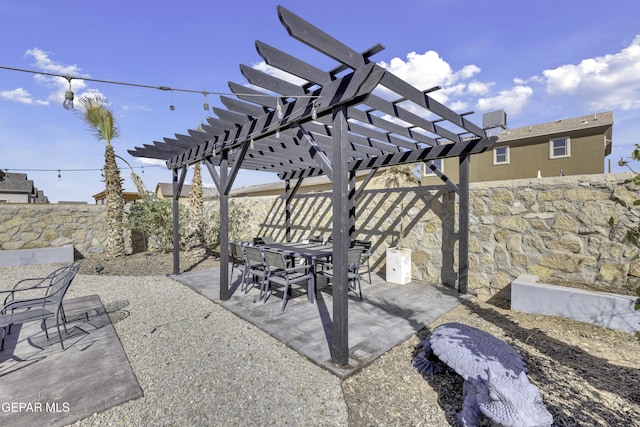 view of patio with outdoor dining space, fence, and a pergola