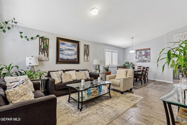 living area with vaulted ceiling, wood finished floors, baseboards, and a textured ceiling