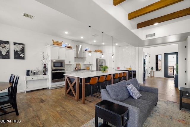 7402 Wooden Nickel Dr, El Paso, TX 79911 - kitchen with light countertops, wall chimney exhaust hood, appliances with stainless steel finishes, and visible vents