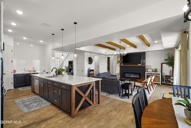 7402 Wooden Nickel Dr, El Paso, TX 79911 - kitchen with light countertops, recessed lighting, a large fireplace, a sink, and light wood-style floors