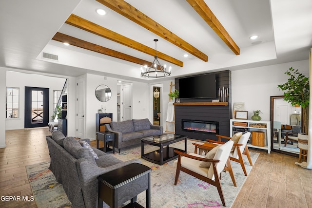 7402 Wooden Nickel Dr, El Paso, TX 79911 - living room featuring a large fireplace, a notable chandelier, light wood-style floors, and visible vents