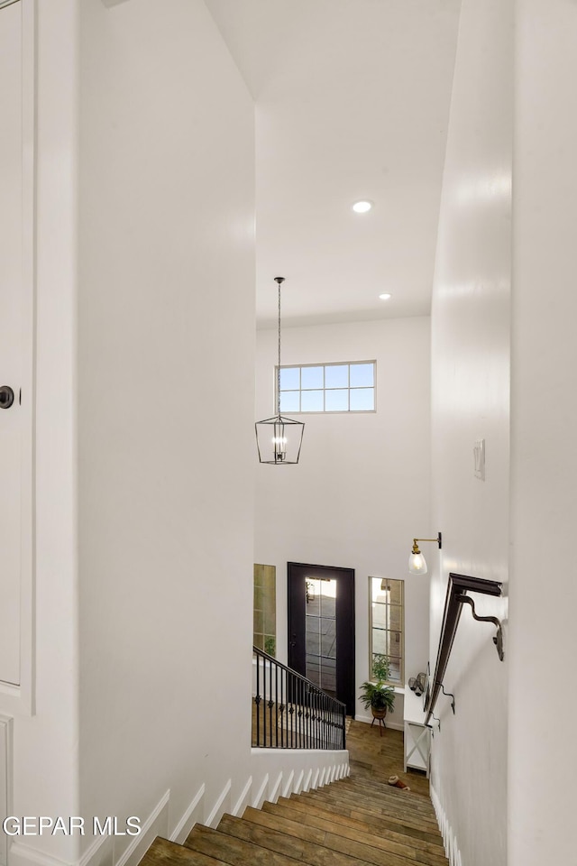 7402 Wooden Nickel Dr, El Paso, TX 79911 - staircase with recessed lighting, an inviting chandelier, baseboards, a towering ceiling, and wood finished floors