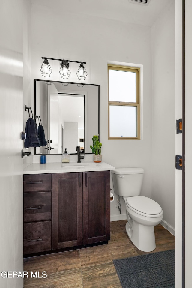 7402 Wooden Nickel Dr, El Paso, TX 79911 - bathroom with visible vents, baseboards, toilet, wood finished floors, and vanity