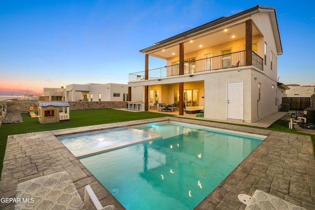 7402 Wooden Nickel Dr, El Paso, TX 79911 - rear view of house with stucco siding, fence, a lawn, a balcony, and a patio area