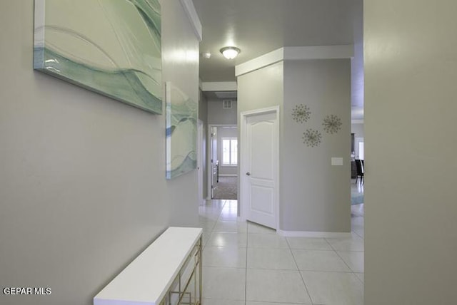 hallway featuring light tile patterned floors and baseboards