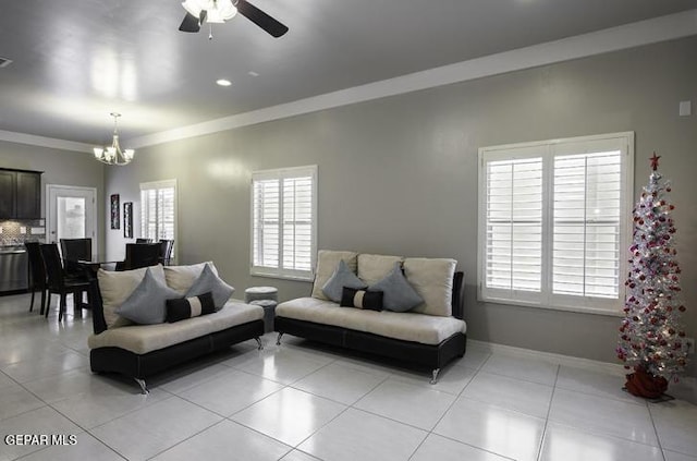 living room with visible vents, ornamental molding, ceiling fan with notable chandelier, light tile patterned flooring, and baseboards